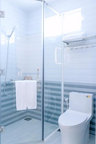 a bathroom with a toilet and a glass shower at M-Homey! Mini Resort in Mỹ Tho