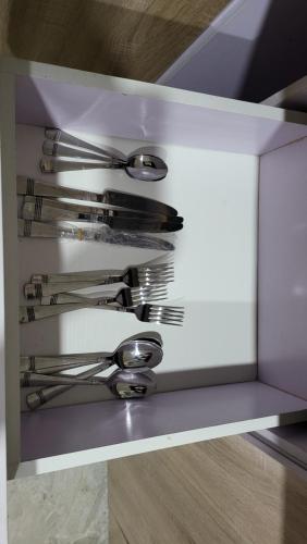 a drawer filled with silver utensils on a shelf at Dvyne Luxury Home in Ikeja