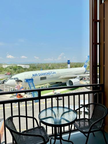 an airplane parked at an airport with a table and chairs at Air Diamond Hotel in Ban Nong Khong