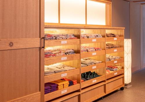 a room with wooden shelving and shelves with shirts at Kashoen in Hanamaki