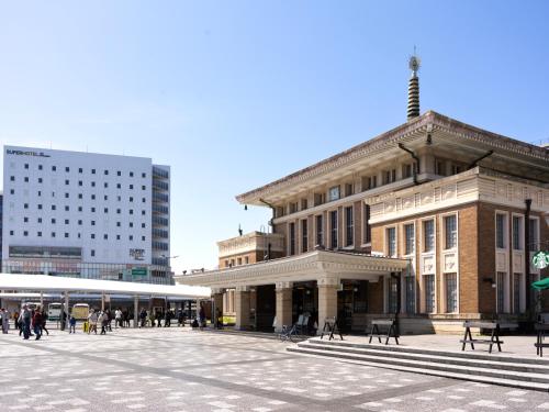 un gran edificio con gente caminando delante de él en Super Hotel Premier JR Nara Eki en Nara