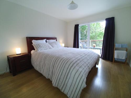 a bedroom with a large bed and a window at Comfortable 2-bedroom unit close to Hamilton, New Zealand in Hamilton