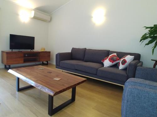 a living room with a couch and a coffee table at Comfortable 2-bedroom unit close to Hamilton, New Zealand in Hamilton