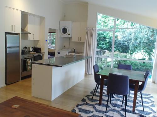 a kitchen and dining room with a table and chairs at Comfortable 2-bedroom unit close to Hamilton, New Zealand in Hamilton