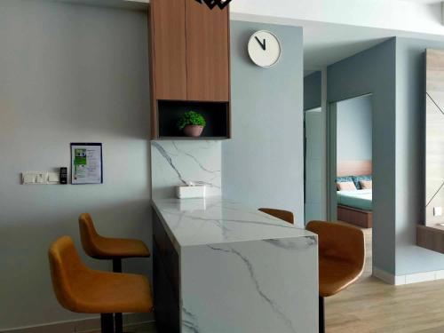 a kitchen with a counter with chairs and a clock at Executive Escapes [The Netizen Cheras] 3房公寓 #MRT in Cheras