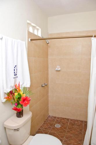 a bathroom with a toilet and a shower with flowers on it at Hotel Hacienda de Vallarta Centro in Puerto Vallarta