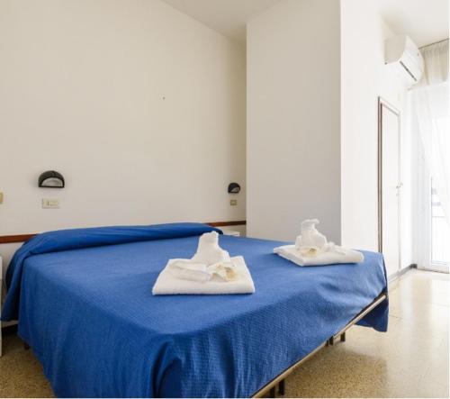 dos toallas están sentadas en una cama en una habitación en Hotel Arena, en Cattolica