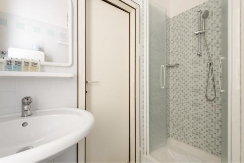a white bathroom with a sink and a shower at Hotel Marea con Piscina NUOVA GESTIONE in Cattolica