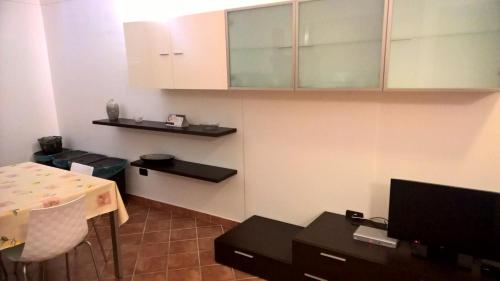 a small room with a table and a kitchen at La Marinella in Palmi