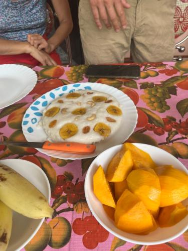una mesa con platos de fruta y un tazón de salsa en Marari kallyani beach homestay, en Mararikulam