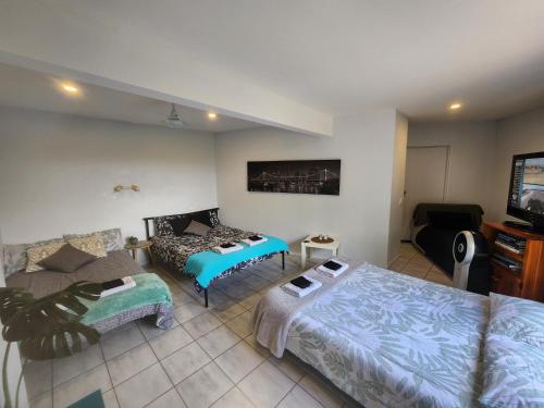 黃金海岸的住宿－Self Contained Guesthouse for 7ppl, w Pool，客厅配有两张床和一台平面电视