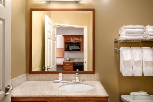 La salle de bains est pourvue d'un lavabo et d'un miroir. dans l'établissement Candlewood Suites LAX Hawthorne, an IHG Hotel, à Hawthorne
