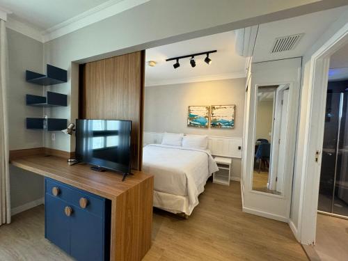 um quarto com uma cama e uma televisão de ecrã plano em Comfort Flat Pinheiros em Hotel 4,5 estrelas em São Paulo