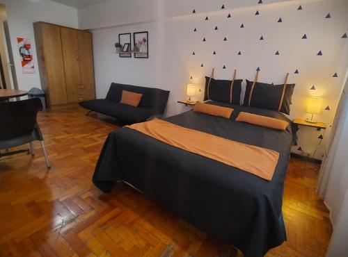 una camera con un grande letto e un divano di Apartment City Heart III a Mendoza