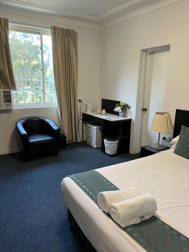 シドニーにあるホテル セント レナーズのベッドとデスクが備わるホテルルームです。