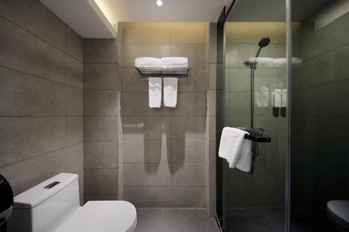 y baño con aseo y ducha con toallas. en Hangyong Ree Hotel (Shenzhen Airport) en Bao'an