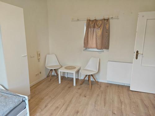 a kitchen with two chairs and a table and a window at Work and Stay 8 Betten 1 Küche 1 Badezimmer 150qm in Geilenkirchen