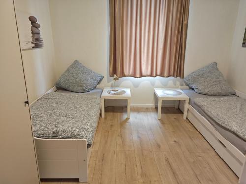 Cette petite chambre comprend deux lits et une table. dans l'établissement Work and Stay 8 Betten 1 Küche 1 Badezimmer 150qm, à Geilenkirchen