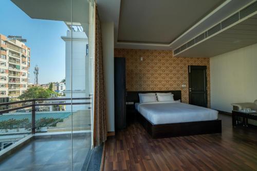 a bedroom with a bed and a balcony at Hotel Anmol Bandhan in Jaipur