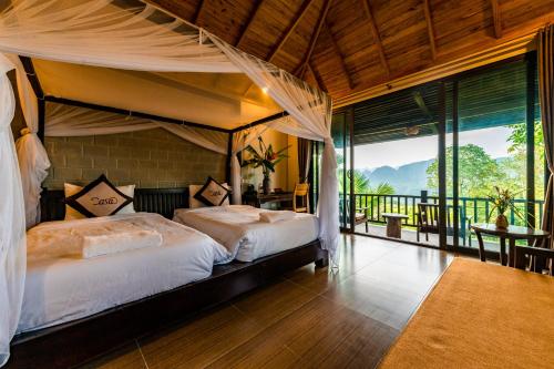 1 dormitorio con cama con dosel y balcón en Puluong Casa Resort, en Hương Bá Thước