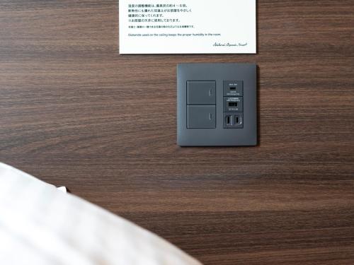 an electronic device on a wooden table with a sign at Super Hotel Premier JR Nara Eki in Nara