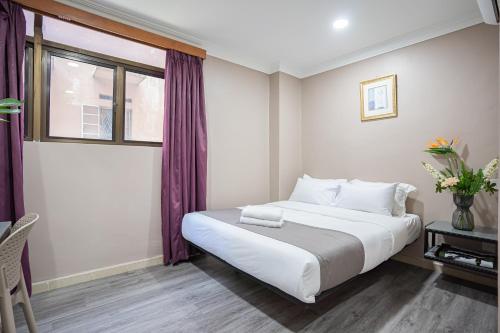 a bedroom with a large bed and a window at HOTEL 28 RAPID in Kuala Lumpur