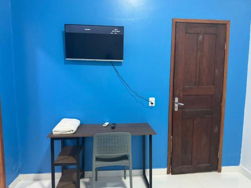 um quarto com uma mesa e uma parede azul com uma porta em Hotel Santa Clara em Belém