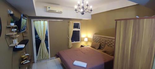 a small bedroom with a bed and a window at Younz Apartemen By Margonda Residence 2 in Pondokcina