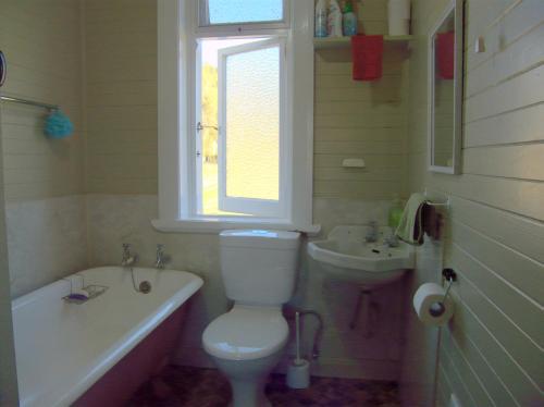 La salle de bains est pourvue de toilettes blanches et d'un lavabo. dans l'établissement Orinoco Country Retreat, à Ngatimoti