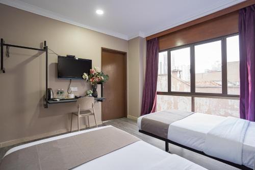 a hotel room with a bed and a desk and a window at HOTEL 28 RAPID in Kuala Lumpur