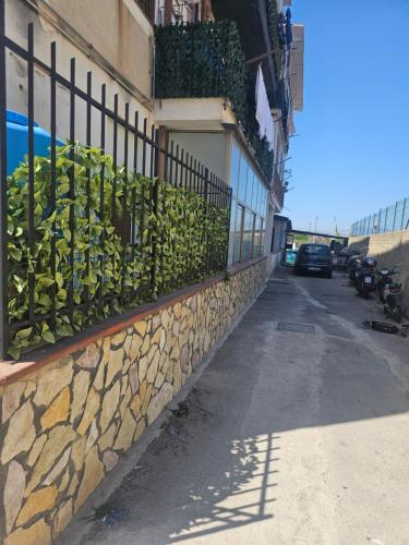 a fence on the side of a building with plants at A casa di Livia in Villabate