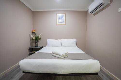 a bedroom with a large white bed with two pillows at HOTEL 28 RAPID in Kuala Lumpur
