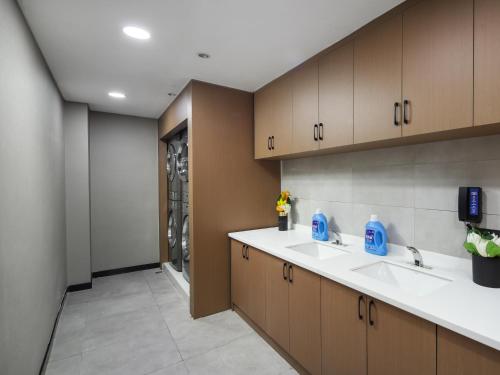 a kitchen with two sinks and a washing machine at Hampton by Hilton Shenzhen Longhua Qinghu in Shenzhen