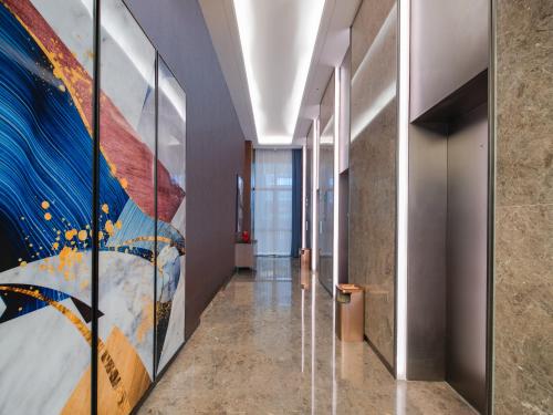 a hallway with a large painting on the wall at Hampton by Hilton Shenzhen Longhua Qinghu in Shenzhen