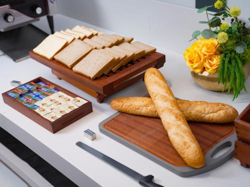 a table with cheese and bread and a cutting board at Hampton by Hilton Shenzhen Longhua Qinghu in Shenzhen