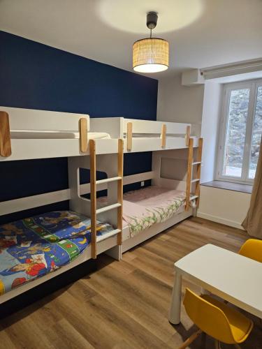 a room with two bunk beds and a table at Appartements 4, 5 et 10 personnes rénovés en centre-ville in Mont-Dore
