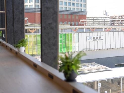 a balcony with potted plants and a view of a building at Super Hotel Premier JR Nara Eki in Nara