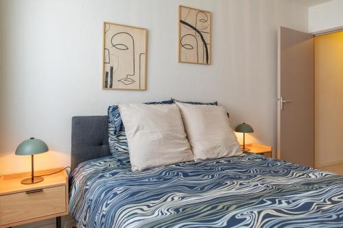 a small bedroom with a bed and two lamps at Villeurbanne Centre Appartement Meublé in Villeurbanne