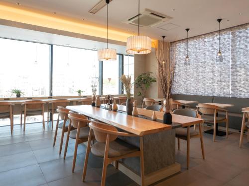 a dining room with a large wooden table and chairs at Super Hotel Premier JR Nara Eki in Nara