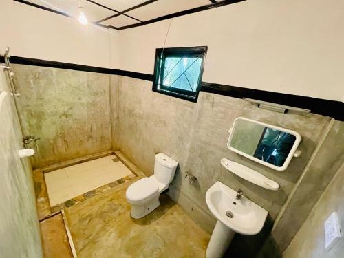 a small bathroom with a toilet and a sink at Ella Jungle Cottage in Ella