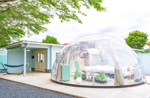 una casa de iguana con parque infantil frente a una casa en TACO GLAMP, en Katori