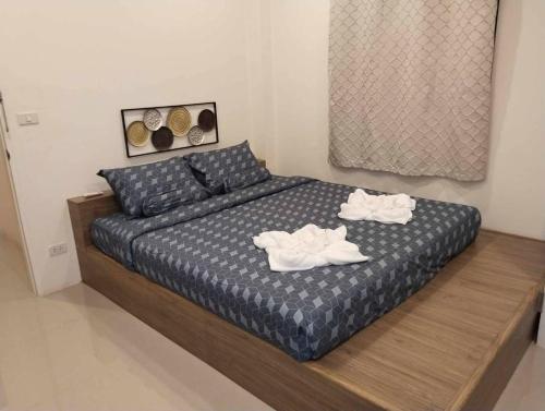 a bedroom with a bed with two towels on it at ขุนโลหะ in Phuket Town