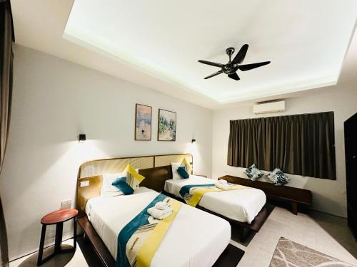a hotel room with two beds and a ceiling fan at summer pool villa in Laguna Phuket