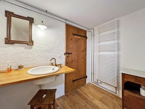 a bathroom with a sink and a mirror at La Maison du Bassin - Grand St Bernard - Orsieres in Orsières