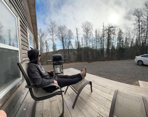 a person sitting in a chair on a deck at Hillside Haven 1 Bedroom with Hot Tub in Sussex