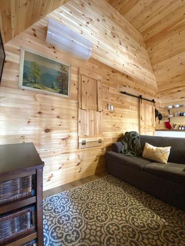 ein Wohnzimmer mit einem Sofa in einer Holzwand in der Unterkunft Hillside Haven 1 Bedroom with Hot Tub in Sussex