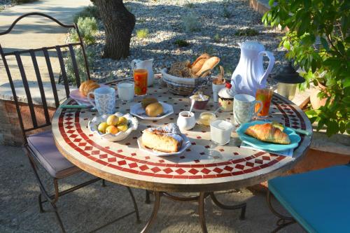 einen Tisch mit einem Teller Essen drauf. in der Unterkunft Les Jardins de l'Ermitage in Les Salles-sur-Verdon