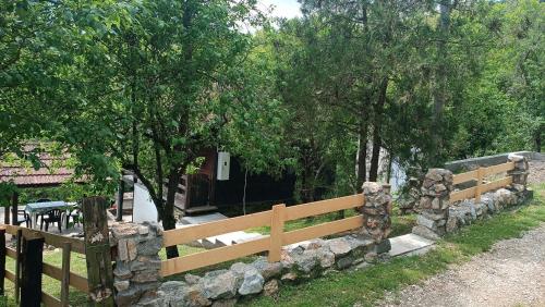 a wooden fence in front of a house with trees at Vikendica Ovčar Banja in Čačak