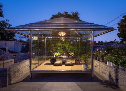a glass gazebo with a living room in it at Beijing Xin xiang YaYuan Countyard Hotel&NearWang Fu Jing Forbidden City Lama Temple and Summer palace,5 minutes walk from subway ,Free Laundry and coffee in Beijing