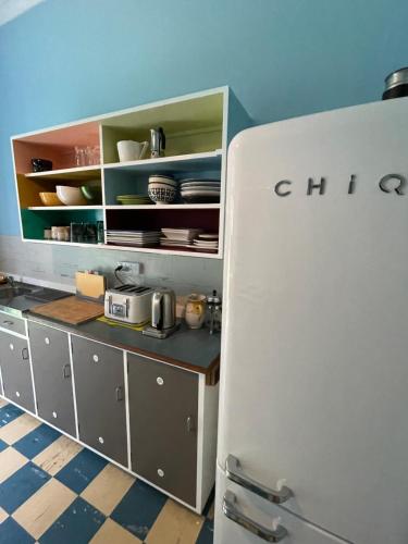 a white refrigerator in a kitchen with some dishes at Babinda Quarters in Babinda